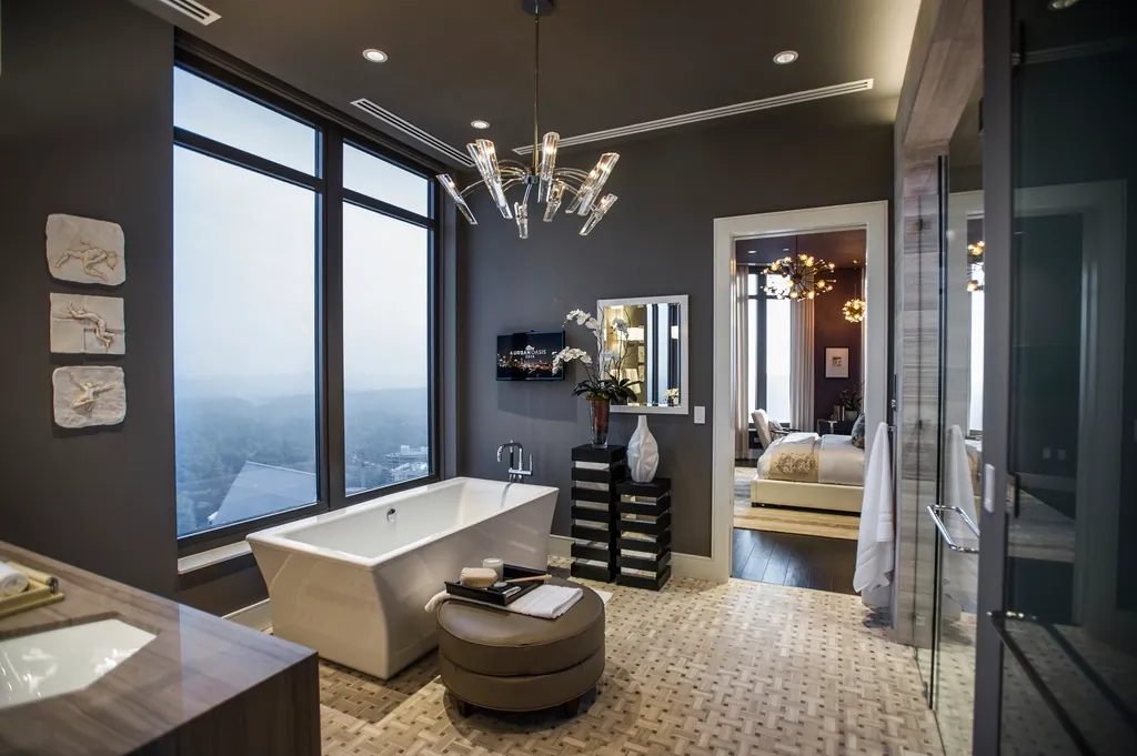 Spacious bathroom with patterned tile floor and a freestanding tub by tall windows
