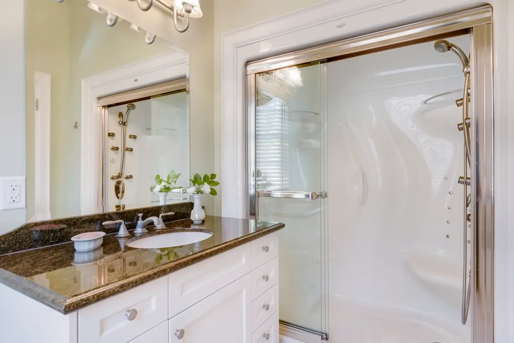 Large format tile floor leading to a glass shower and a doorway