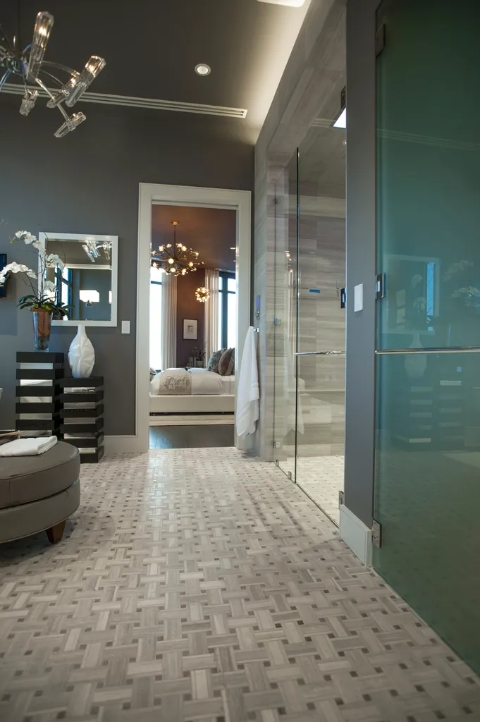 Freestanding tub on a brown tile floor in a bright bathroom
